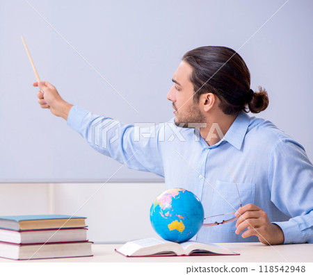 Young male geography teacher in front of whiteboard 118542948