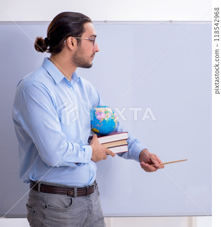 Young male geography teacher in front of whiteboard Young male geography teacher in front of whiteboard 118542968