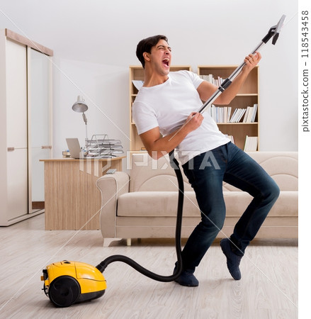 Man cleaning home with vacuum cleaner Man cleaning home with vacuum cleaner 118543458