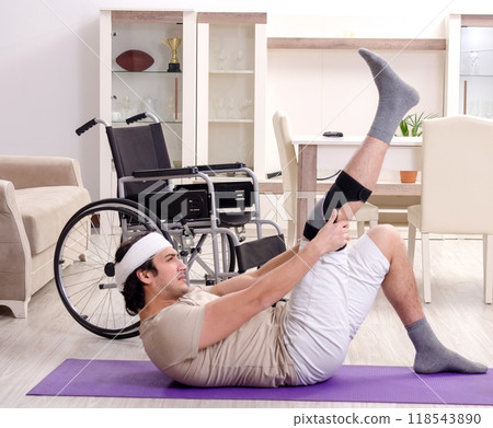 Injured young man doing exercises at home Injured young man doing exercises at home 118543890