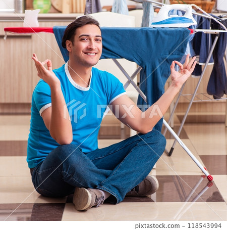 Young man husband doing clothing ironing at home Young man husband doing clothing ironing at home 118543994