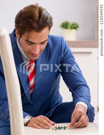 Office prank with sharp thumbtacks on chair 118544035