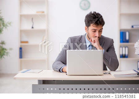 Young male employee and too much work in the office 118545381
