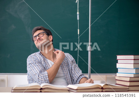 Young male teacher suffering in the classroom Young male teacher suffering in the classroom 118545391