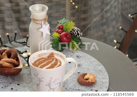 Ceramic cappuccino cup and table decor. Christmas festivities. Background for design. Ceramic cappuccino cup and table decor. Christmas festivities. Background for design. 118545569