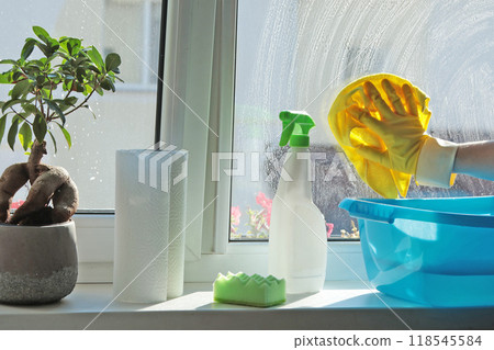 Woman wearing rubber gloves washing window in house. Cleaning and cleanliness, detergents. Woman wearing rubber gloves washing window in house. Cleaning and cleanliness, detergents. 118545584
