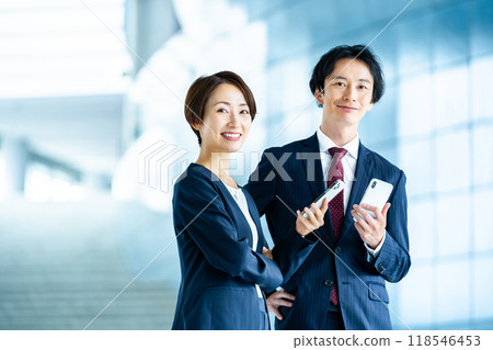 Male and female employees with smartphones Business image Male and female employees with smartphones Business image 118546453