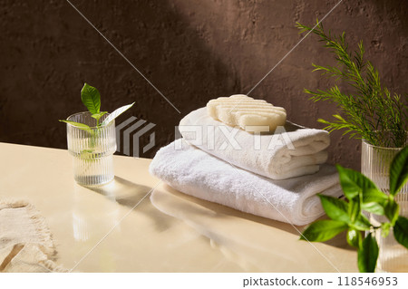 The advertising photo from high angle view with spa concept, product displaying space on beige table top, which featuring glass jars , green plants, spa towel and soap on The advertising photo from high angle view with spa concept, product displaying space on beige table top, which featuring glass jars , green plants, spa towel and soap on 118546953