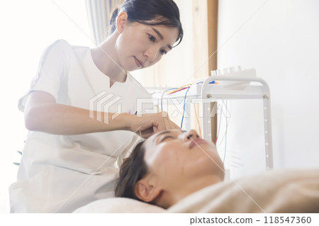 Acupuncturist performing cosmetic acupuncture Acupuncturist performing cosmetic acupuncture 118547360