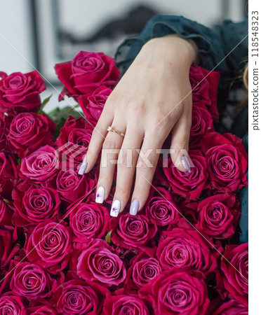 Betrothal ring on woman hand with pink bouqet of roses. Romantic event. Betrothal ring on woman hand with pink bouqet of roses. Romantic event. 118548323