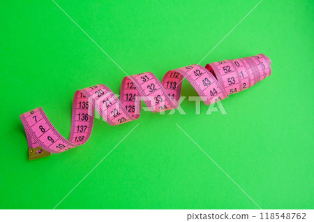 Pink centimeter measure tape on colorful background Pink centimeter measure tape on colorful background 118548762