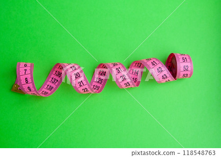Pink centimeter measure tape on colorful background Pink centimeter measure tape on colorful background 118548763