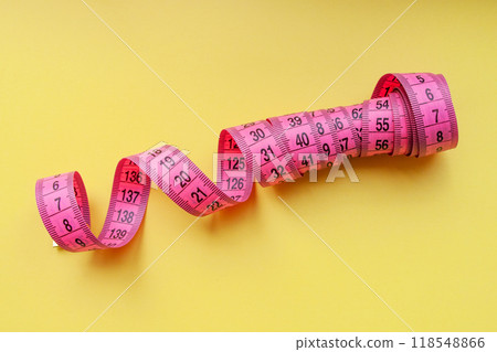 Pink centimeter measure tape on colorful background 118548866