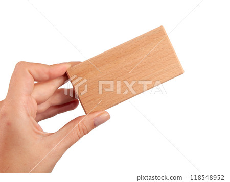 Wooden brick block in hand isolated on the white Wooden brick block in hand isolated on the white 118548952
