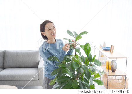 Woman caring for foliage plants 118549598