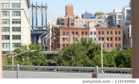 New York City Manhattan Bridge from Brooklyn Bridge. Red brick building, yellow taxi car on road. 118549966