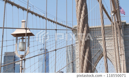 Brooklyn Bridge cables, Manhattan downtown. New York City skyline, financial district cityscape. Brooklyn Bridge cables, Manhattan downtown. New York City skyline, financial district cityscape. 118550071