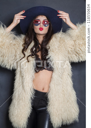 Stylish woman with red lips make-up and long wavy hair wearing blue hat Stylish woman with red lips make-up and long wavy hair wearing blue hat 118550634