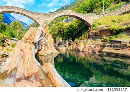 Ancient double arch stone Roman bridge (Ponte dei Salti) over the clear water of the Verzasca river in Lavertezzo ,Verzasca Valley, Ticino Canton, Switzerland 118551527