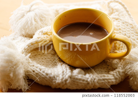 Cup of delicious hot chocolate on warm sweater on wooden table background. Selective focus. 118552003