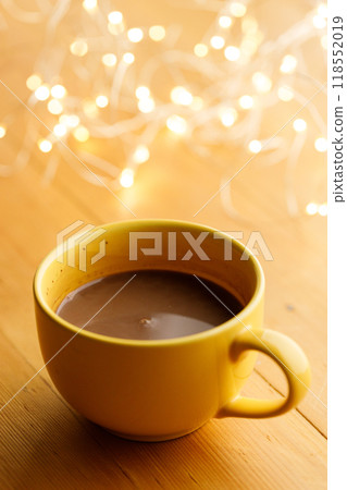 Cup of delicious hot chocolate under with light bokeh on wooden table background. Selective focus. 118552019