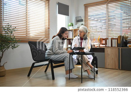 Experienced senior doctor having a discussion with a young female patient in medical office Experienced senior doctor having a discussion with a young female patient in medical office 118552366