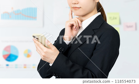 拿著智慧型手機和思考的年輕女商人 118554073