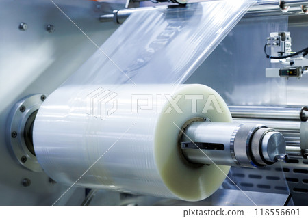 roll of plastic packaging film on the automatic packing machine in food product factory. industrial and technology concept. 118556601