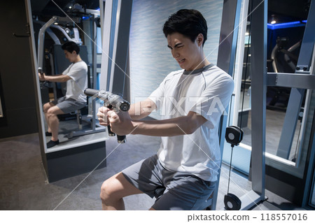 Man training at a sports gym: weight training with chest press 118557016