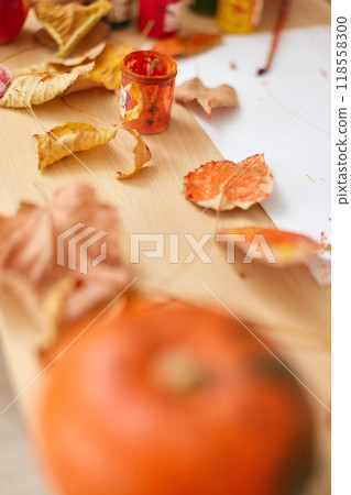 autumn leaves with paintbrush on paper on table, autumn children background 118558300