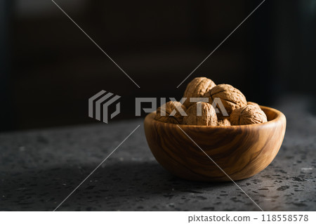 inshell walnuts in olive wood bowl on terrazzo countertop 118558578