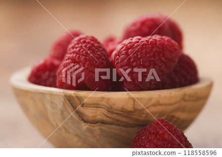 fresh raspberries in wood bowl on table 118558596