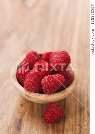 fresh raspberries in wood bowl on table with copy space 118558597