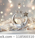 3D rendering of a silver crescent moon and stars hanging on a white cloth background with bokeh lights. 118560310
