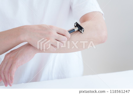 Man shaving his arm hair with a razor Man shaving his arm hair with a razor 118561247