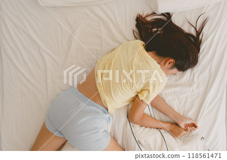 Above view of woman sleeping on white bed in very cozy pose. 118561471