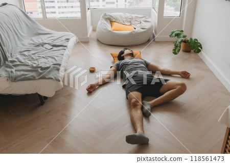 Wide angle of man napping on the floor in the living room. Wide angle of man napping on the floor in the living room. 118561473
