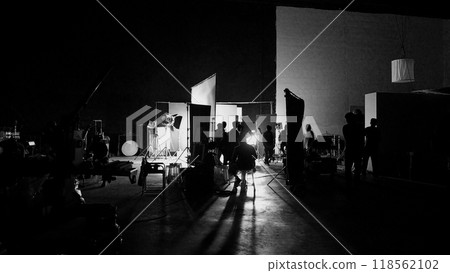 Silhouette of film crews and video camera on special dolly crane with film lights equipment and blue screen set. Film Production behind the scenes studio set in silhouette style. Behind video shooting 118562102