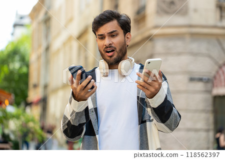 Stressed Indian man talking screaming on mobile phones having conflict quarrel complaint on street Stressed Indian man talking screaming on mobile phones having conflict quarrel complaint on street 118562397