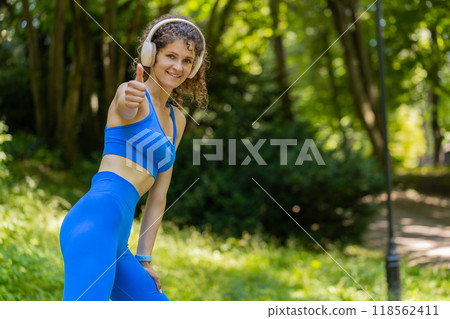 Athletic fitness sport motivated runner girl training marathon run, starting race showing thumb up Athletic fitness sport motivated runner girl training marathon run, starting race showing thumb up 118562411