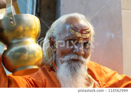 Ascetic monk Sadhu in India with beard, white hair and painted face preaching Ascetic monk Sadhu in India with beard, white hair and painted face preaching 118562994