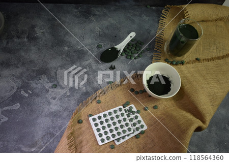 a spoonful of green seaweed powder, pills and capsules. A glass of smoothie a spoonful of green seaweed powder, pills and capsules. A glass of smoothie 118564360