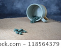 Green seaweed powder, pills and capsules in a cup on a black background 118564379