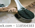 a spoonful of green seaweed powder, pills and capsules 118564383