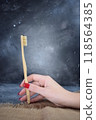 A bamboo toothbrush in the hand of a young girl.  118564385
