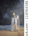 Two bamboo toothbrushes in a glass cup.  118564386