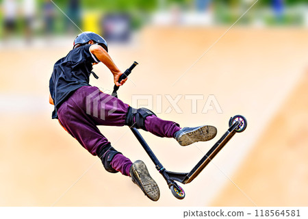 Young man practicing Scootering (Freestyle Scootering) in the new SkatePark in the central park of Igualada, Barcelona, Spain. blurred background 118564581
