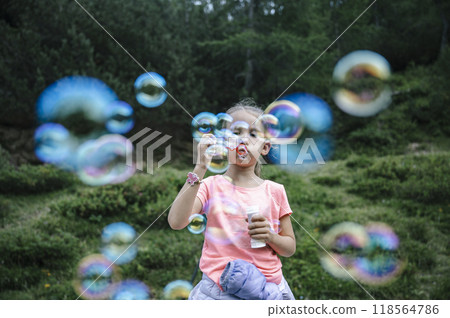 Toddler girl blowing soap bubbles 118564786