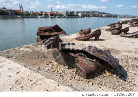 Budapest, Hungary. 25 August 2022. Memorial to the victims of the Nazi repression. Rusty metal copies of old shoes on the Danube River embankment. Holocaust and Nazi terror memory concept. Budapest, Hungary. 25 August 2022. Memorial to the victims of the Nazi repression. Rusty metal copies of old shoes on the Danube River embankment. Holocaust and Nazi terror memory concept. 118565207