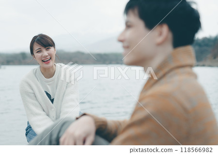 20 多歲的男性和女性在戶外微笑和交談 20 多歲的男性和女性在戶外微笑和交談 118566982